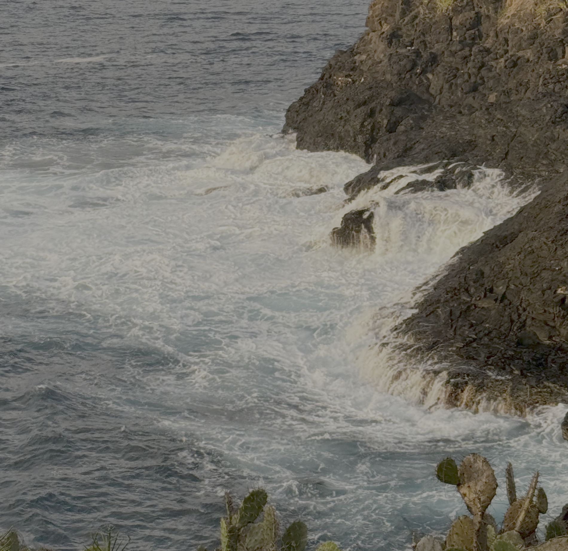 Waves breaking against the cliffs of the Bukit Peninsula